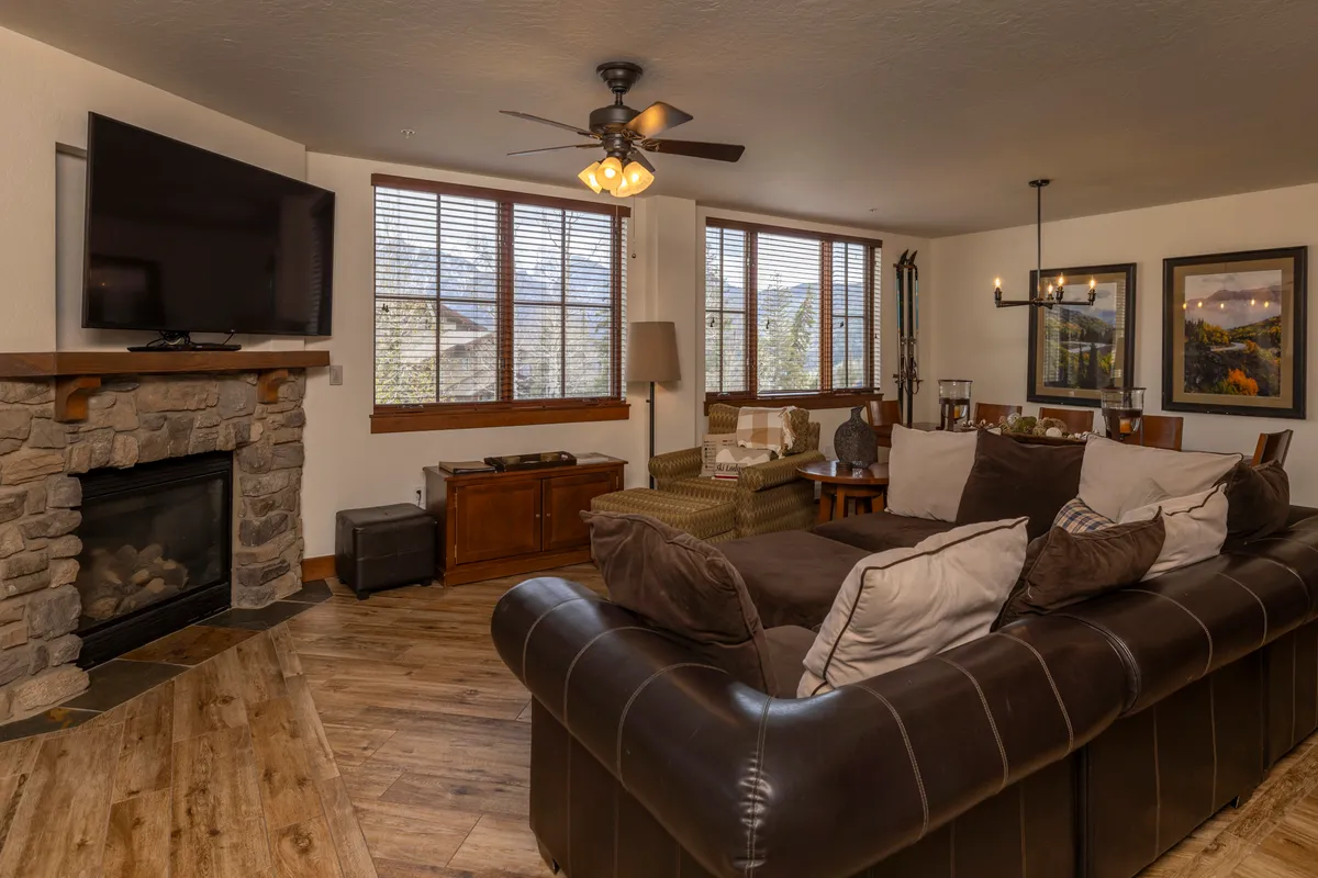 A spacious living area with a large sectional sofa, fireplace, TV, and windows offering views to the outside. The space invites relaxation, socializing, and recounting the day’s highlights after exploring all that Durango has to offer.